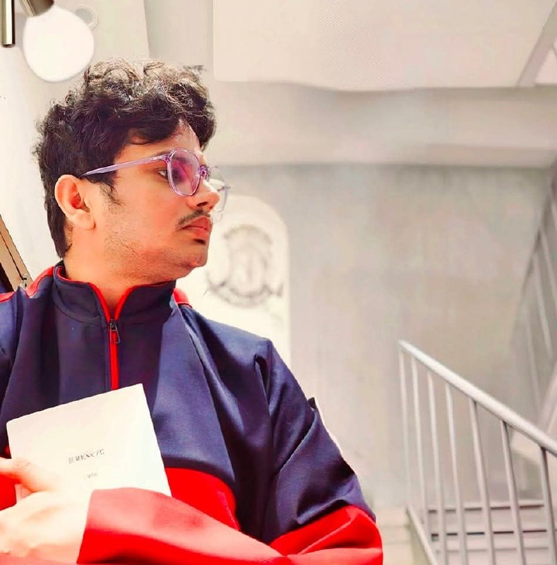 Shakti Tiwari — holding a book, purple glasses